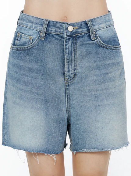 Classic Washed Jorts IU525 Blue close-up front detail on model, showing button fly, coin pocket, golden stitching, and washed denim texture