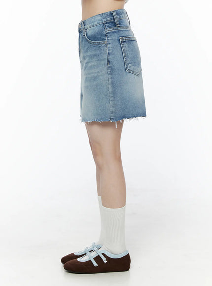 Classic Washed Jorts IU525 Blue side view on model showing patch back pocket, side seam, and frayed raw hem with white socks and mary jane flats