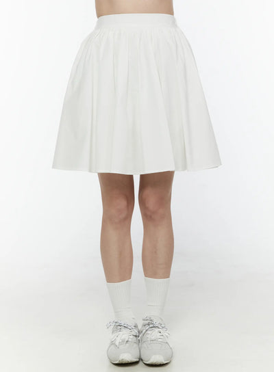 LEWKIN Colette A-Line Midi Skirt IL506 White front view on model cropped at waist showing full pleated A-line silhouette paired with white socks and sneakers size S/M