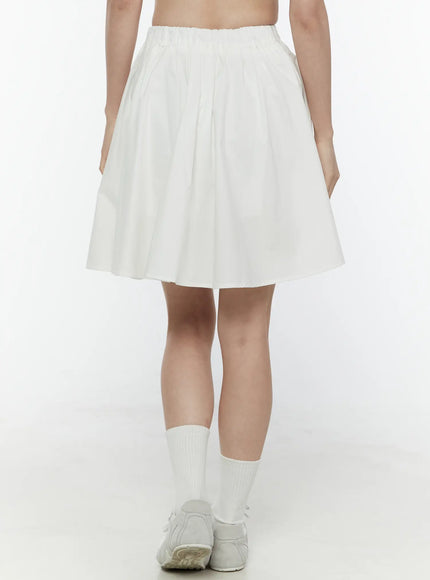 Colette A-Line Midi Skirt IL506 White front full-body on model showing elasticated waistband pleated flare skirt hem above knee white socks and sneakers