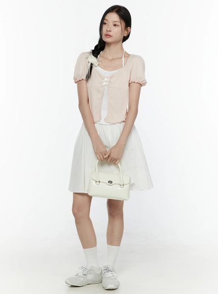 Colette A-Line Midi Skirt IL506 White full-body styling shot on model wearing pink puff-sleeve cardigan holding white handbag with white socks and sneakers