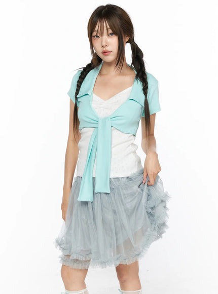 Collared Tie Short Sleeve Crop Bolero CL514 Mint front shot model holding tulle skirt hem mint tie-front crop bolero over white eyelet top with gray tulle skirt cropped view