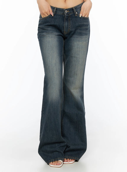 Collins Vintage Washed Bootcut Jeans IL523 Dark blue front shot cropped at waist model hands in pockets showing faded wash low-rise waistband and wide bootcut legs