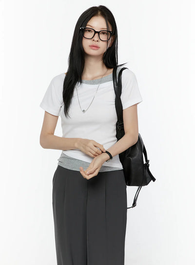 LEWKIN Color Contrast Asymmetric Short Sleeve Top IL506 White S/M front shot on model wearing glasses, silver necklace, and black backpack
