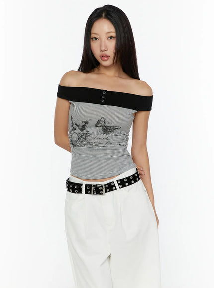 Color Contrast Off-Shoulder Graphic Top CU529 Dark gray front model shot standing upright black off-shoulder band with snap buttons butterfly graphic on striped knit body
