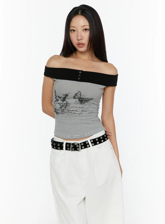 Color Contrast Off-Shoulder Graphic Top CU529 Dark gray front model shot standing upright black off-shoulder band with snap buttons butterfly graphic on striped knit body