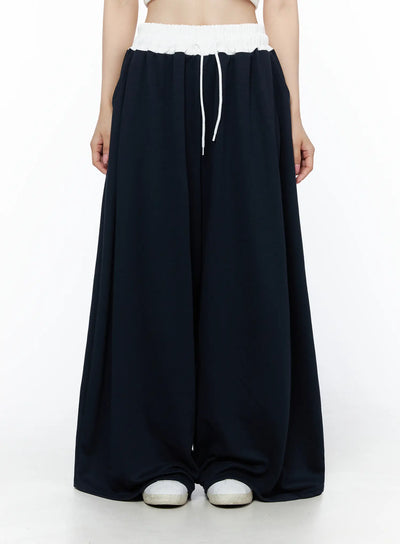LEWKIN Color Contrast Wide-Leg Sweatpants IU525 Dark blue front view on model wearing white crop top, white elastic waistband with drawstring, ultra-wide leg silhouette