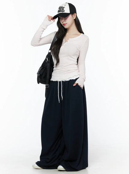 Color Contrast Wide-Leg Sweatpants IU525 Dark blue side styled shot on model adjusting baseball cap with crossbody bag, wide-leg silhouette and white drawstring waist
