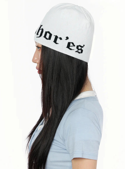 Contrast Graphic Text Reversible Beanie IL516 White side profile model shot, female with long hair showing full side silhouette of knit beanie, gothic text band visible