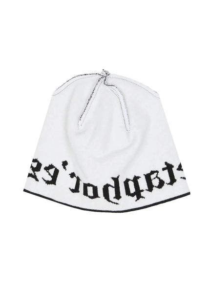 Contrast Graphic Text Reversible Beanie IL516 White product flat shot, inside-out view displaying reversed gothic text lettering and raw seam detail at crown