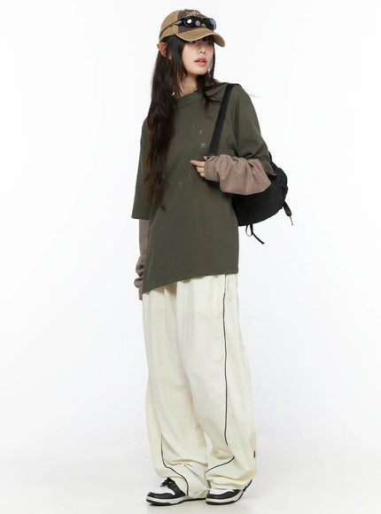 Contrast Piping Nylon Wide Pants CL523 Light beige styled outfit shot model wearing cap and backpack full body angled pose
