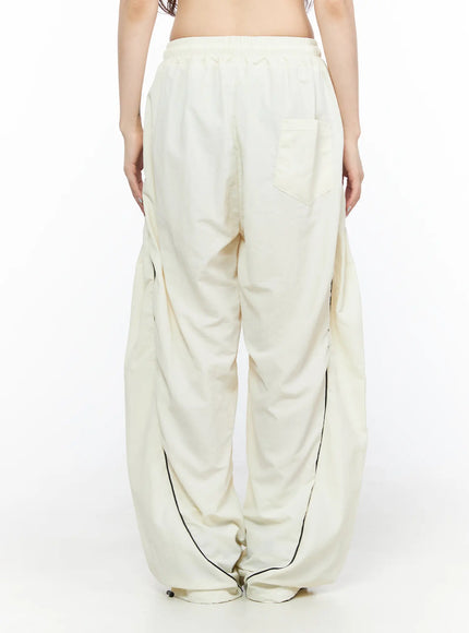 Contrast Piping Nylon Wide Pants CL523 Light beige back view on model showing single back pocket elastic waistband and black piping at hem
