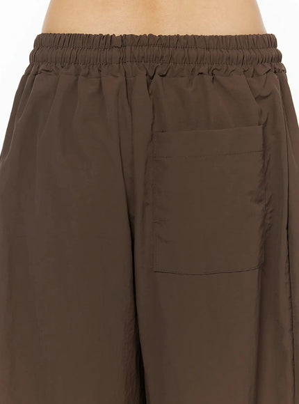 Contrast Stripe Track Pants IL509 Brown back view close-up on model showing elastic waistband, patch back pocket and voluminous wide-leg silhouette