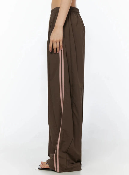 Contrast Stripe Track Pants IL509 Brown close-up detail of cream drawstring, elastic waistband and pink contrast side stripes on nylon fabric