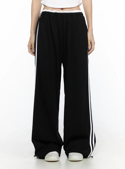 Contrast Stripe Wide Leg Sweatpants CL524 Black front shot on model showing wide-leg silhouette double white side stripes ruffled elastic waistband and drawstring hem with sneakers
