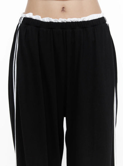 Contrast Stripe Wide Leg Sweatpants CL524 Black close-up front shot on model showing ruffled white elastic waistband double white side stripes and relaxed wide-leg fabric texture