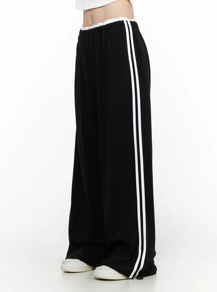 LEWKIN Contrast Stripe Wide Leg Sweatpants CL524 Black side shot on model standing straight with white sneakers showing double white side stripes and ruffled elastic waistband