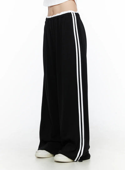 LEWKIN Contrast Stripe Wide Leg Sweatpants CL524 Black side shot on model standing straight with white sneakers showing double white side stripes and ruffled elastic waistband