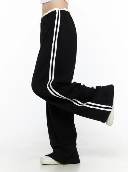 Contrast Stripe Wide Leg Sweatpants CL524 Black side shot on model with leg kicked up showing white double side stripes wide-leg silhouette and ruffled waistband detail