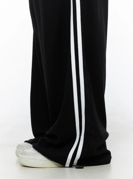 Contrast Stripe Wide Leg Sweatpants CL524 Black close-up detail shot of lower leg and hem showing double white side stripe drawstring hem detail and white sneakers