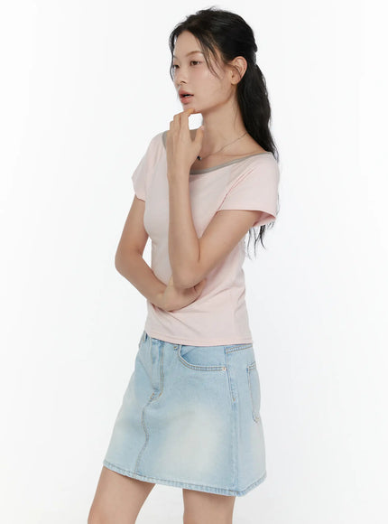 Contrast Trim Boat Neck Tee CL521 Light pink side shot on model hand touching chin showing slim silhouette grey neckline trim and short cap sleeves