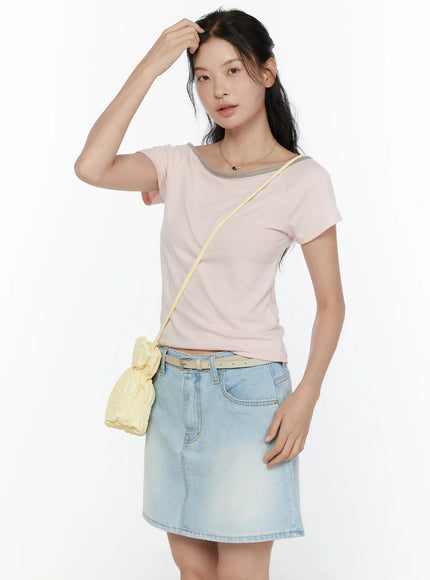 LEWKIN Contrast Trim Boat Neck Tee CL521 Light pink three-quarter front shot on model hand raised to hair styled with denim mini skirt and yellow crossbody bag