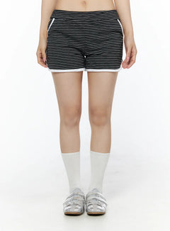 LEWKIN Contrast Trim Striped Shorts IU525 Black front close-up on model showing horizontal stripe pattern and white contrast trim hem