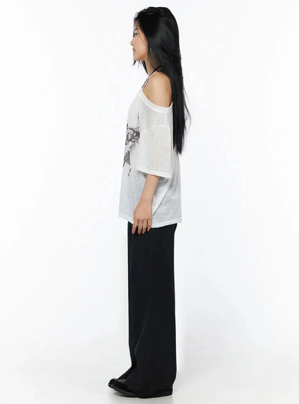Corset Graphic Off-Shoulder Oversized Tee IL516 White side shot model standing profile sheer fabric off-shoulder asymmetric neckline relaxed oversized silhouette black wide-leg pants