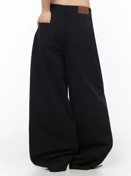 Cotton Balloon Pants IL502 Black rear three-quarter model shot, back pockets and brown leather LEWKIN logo patch on waistband close-up detail