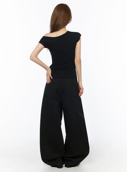 Cotton Balloon Pants IL502 Black back view on model, showing back patch pockets and rear waistband with brown leather logo patch, wide flared legs