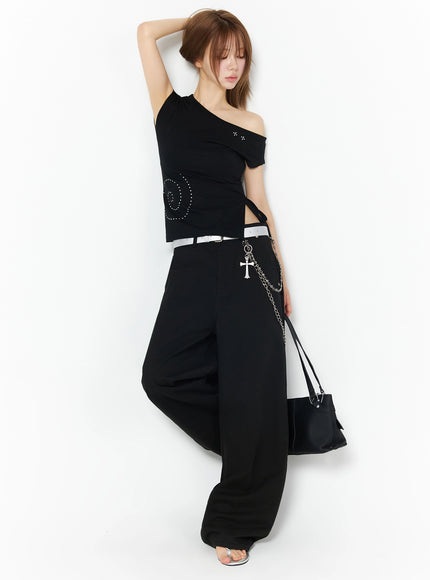 Cotton Balloon Pants IL502 Black editorial side-angle model shot, one leg raised, arm up with black bag and white belt chain styling, fashion pose