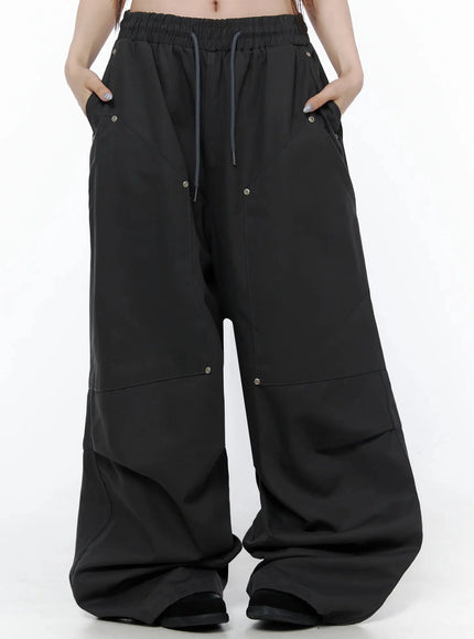 Cotton Carpenter Wide Pants IL502 Dark gray front view on model with hands in pockets showing wide leg drape elastic waist and eyelet hardware
