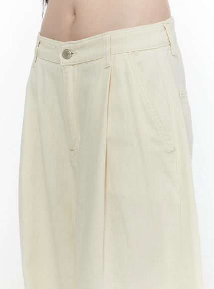 Cotton Wide Leg Pants IL521 Light beige close-up detail of waistband, silver button, pleats, and denim twill texture on model