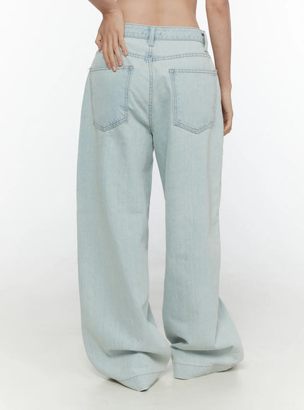 Cove Washed Wide Leg Jeans CL521 Light blue back three-quarter view on model showing wide leg silhouette, dual back pockets, and hand resting on waistband