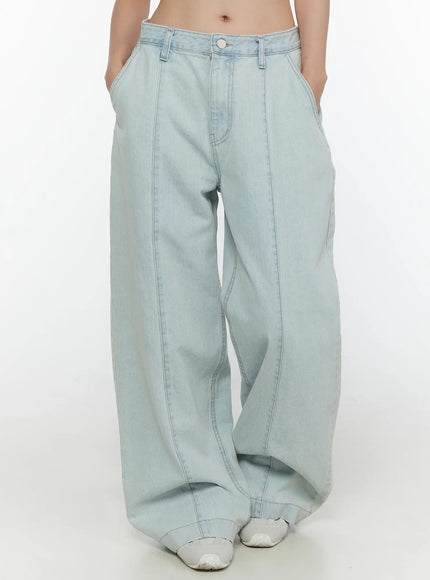 Cove Washed Wide Leg Jeans CL521 Light blue front view on model with hands in pockets showing low-rise fit, front vertical seams, wide leg volume, and white sneakers