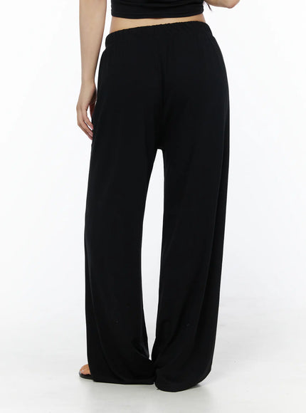 Crop Cami, Cardigan & Sweatpants Set IU525 Black back close-up on model showing elastic waistband and relaxed wide-leg trouser silhouette from rear angle with sandals