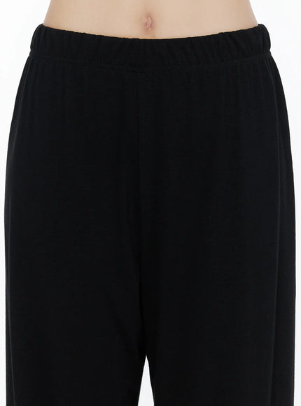 Crop Cami, Cardigan & Sweatpants Set IU525 Black close-up detail shot on model showing elastic waistband texture and wide-leg trouser fabric with smooth jersey material