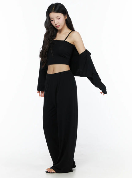 Crop Cami, Cardigan & Sweatpants Set IU525 Black three-quarter front shot on model looking down, cardigan slipped off one shoulder over cami, wide-leg pants full-length view