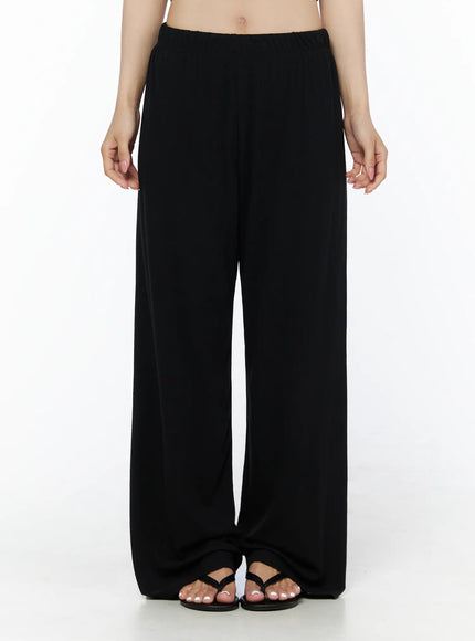 Crop Cami, Cardigan & Sweatpants Set IU525 Black front close-up on model showing elastic waistband detail of wide-leg sweatpants with bare midriff and sandals