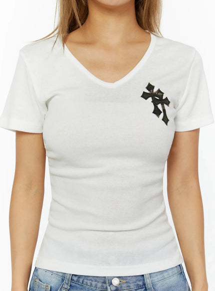 Cross Detail V-Neck Tee IL524 White close-up front shot on model showing camo-patterned cross patch detail on chest, V-neck ribbed cotton fabric