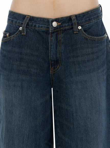 Cruz Wide Leg Jeans IL523 Dark blue close-up detail of front waistband, low-rise silver button closure, contrast orange topstitching, five-pocket construction