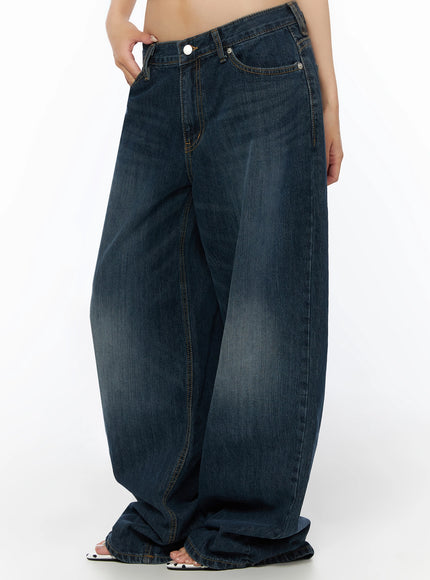 Cruz Wide Leg Jeans IL523 Dark blue side close-up from waist down, hand in pocket, balloon-style wide leg with heavy fading and contrast stitching, sandals