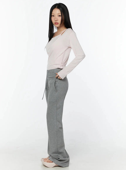 Cuffed Flare Lounge Pants IU524 Gray side full-length shot on model hand in pocket wearing pink long-sleeve top showing flare leg and seam detail