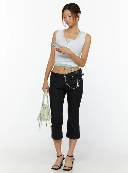 LEWKIN Cyril Low-Rise Capri Jeans CL515 Black full-body front shot on model holding phone styled with mint crop top chain belt and green bag