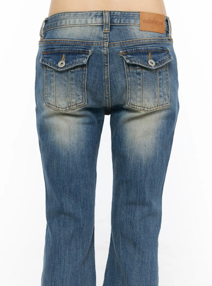 Dawn Low Rise Bootcut Jeans CU530 Blue close-up back detail shot on model showing flap pockets with snap buttons, orange stitching and ozbridge leather patch