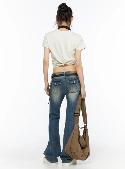 Dawn Low Rise Bootcut Jeans CU530 Blue back shot on model styled with cream crop top, braided belt and canvas tote showing full bootcut flare