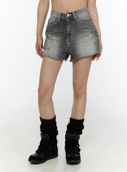 Distressed Mini Denim Shorts CL507 Black front view on model with black sneakers and leg warmers, washed gray denim with distressed details and frayed hem