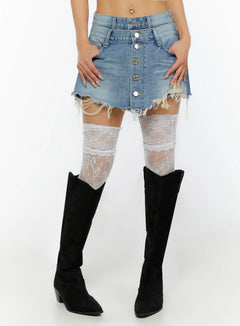 LEWKIN Distressed Mini Denim Skirt IL524 Blue Size S front close-up on model showing button-fly detail and frayed hem with white lace thigh-high socks and black boots