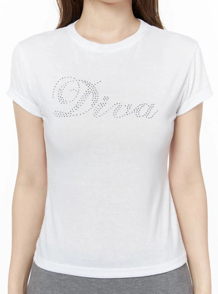 Diva Short Sleeve Tee IU525 White close-up chest detail on model showing silver rhinestone cursive Diva script graphic on soft cotton fabric