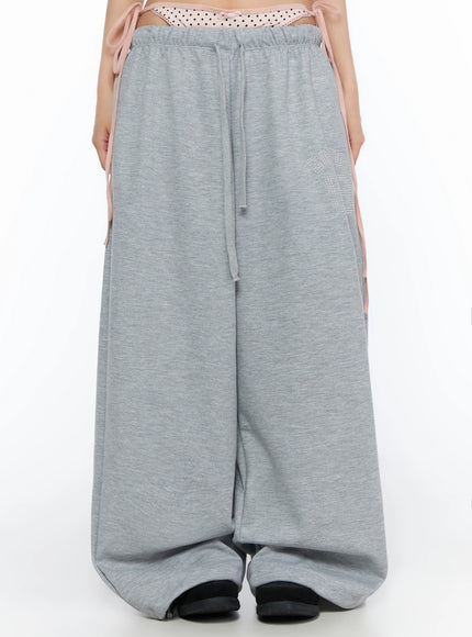 LEWKIN Dot Print Sagging Sweatpants IL515 Gray front close-up on model showing pink polka dot layered waistband with drawstring and rhinestone logo detail
